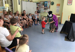 Pani Magik i dziecko z widowni prezentują sztuczkę
